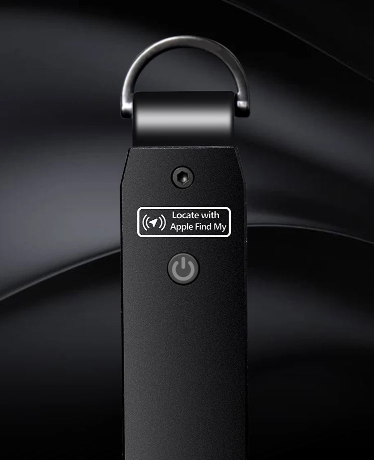 Close-up of the NURVION keychain's metal keyring loop and power button in matte black finish, with a Locate with Apple Find My label